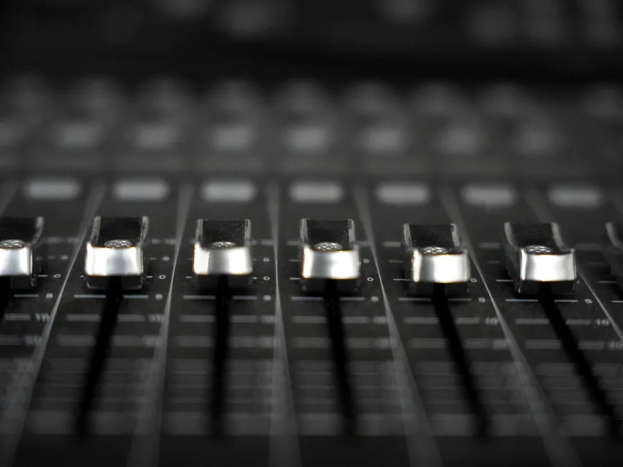 Operator teknis mengatur fader mixer selama acara berlangsung